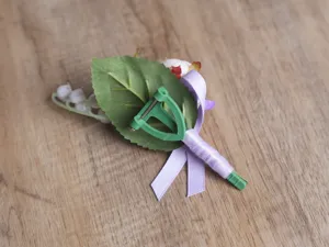 Koreanischer Hochzeits-Boutonnière Detailansicht, mit lila Band und grünen Blättern.