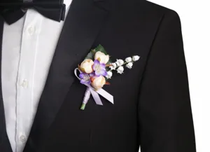 Elegante Hochzeits-Boutonniere mit zarten rosa und lila Blumen sowie weißem Maiglöckchen.