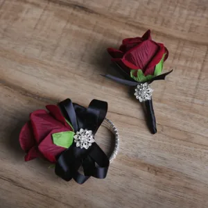 Ensemble boutonnière et corsage de poignet de mariage rose bordeaux avec ruban noir.