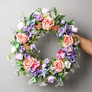 Kunstblumenkranz Detail mit rosa und lila Rosen und Hortensien fuer die Wanddeko.