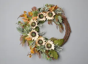 Ghirlanda autunnale artificiale di girasole con foglie d'acero e base in rattan da parete.