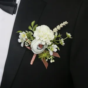 Boutonniere detail shot showing elegant white and blue artificial flowers on a black suit lapel.