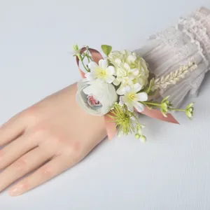 Stunning wedding wrist flower corsage with pink ribbon and delicate white artificial flowers.