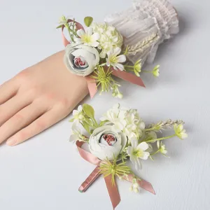 Wedding wrist flower and boutonniere set with pink ribbon and floral design for brides.