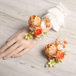 Orange rustic artificial wrist flower and boutonniere set, ideal for wedding parties.