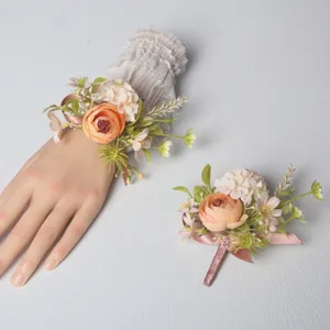 Detailed shot of European wedding artificial rose wrist flower and matching boutonniere set.