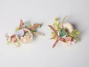 Detailed view of European wedding boutonniere and pearl wrist flower set with back clip.