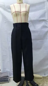 Vista detallada de pantalones casuales negros de talle alto y pierna ancha con doble botón.