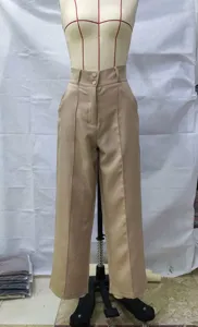 Vista detallada de pantalones anchos caquis de talle alto con cierre de doble botón y pliegues.