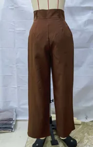Detalle de pantalón ancho marrón de talle alto con presillas y textura de tela.