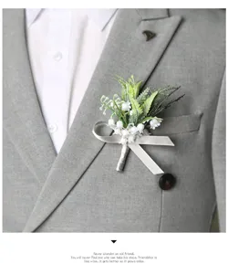 Elegant grey suit boutonniere corsage with white floral design for wedding and business meetings.