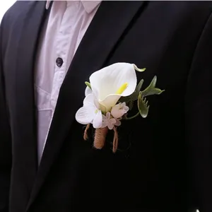 Close up detail of elegant white calla lily groom boutonniere with twine wrapped stem for wedding.