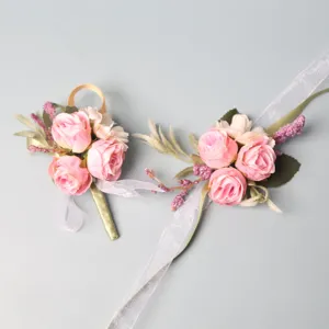 Artificial pink rose wedding boutonniere and wrist corsage set with ribbons for bride groom.