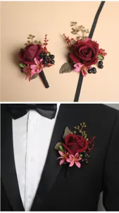 Gedetailleerd uitzicht op de bordeauxrode kunstmatige roos trouwcorsage en polscorsageset.