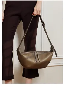 Gedetailleerde close-up van de vintage lederen halve maan croissant tas met verstelbare riem.