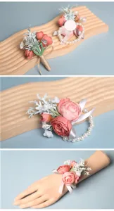 Elegante rosa Kamelie Hochzeits-Handgelenksblume mit Perlenarmband und Schleife für Braut.