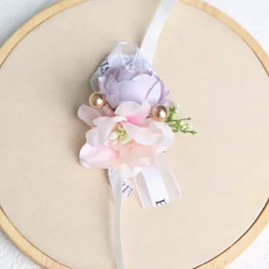 Detalle de corsage de muñeca de boda coreano con flor morada, rosa y perlas doradas.