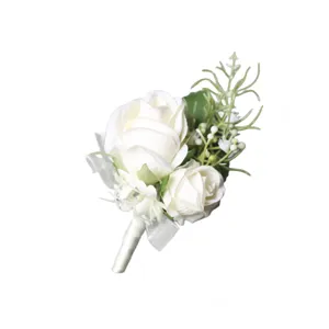 Élégante boutonnière de mariage rose blanche avec feuilles vertes et ruban blanc pour le marié.