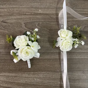 Artificial white rose wrist flower and groom boutonniere set for outdoor wedding decoration.