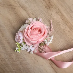 Detalle de ramillete de muñeca de rosa artificial rosa, elegante accesorio floral de boda.