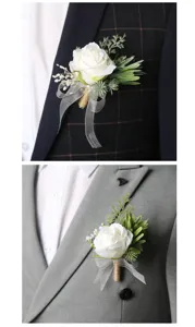 Detailed view of white artificial rose wedding boutonnière with green leaves and ribbon for groom.