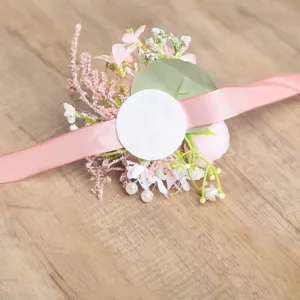 Vista detallada del corsaje de muñeca de flores artificiales rosadas para boda elegante.