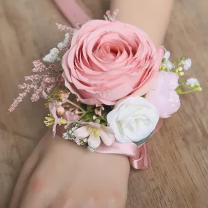 Vista detallada del elegante ramillete de muñeca de rosas rosa y blancas con cinta nupcial.