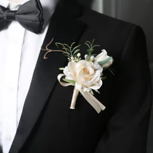 Elegant white rose wedding boutonnière with green leaves and ribbon for groom, suit jacket.