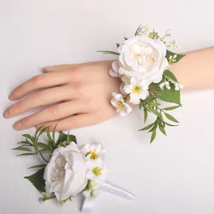 Ensemble de fleurs de poignet et boutonnière de mariage blanc pour fête de mariés.