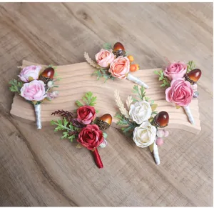 Detail view of artificial rose boutonnieres with berries and leaves for rustic weddings.