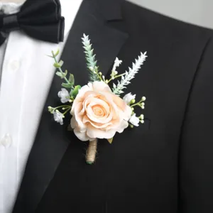 Dettaglio di boutonniere da sposa con rosa champagne elegante, foglie verdi e spago.