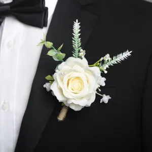 Primo piano dettagliato del boutonniere di rosa artificiale bianca sul risvolto dell'abito.