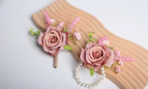 Primo piano di boutonnière di rose artificiali e corsage da polso di perle per matrimonio.