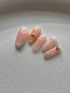 Vista detallada de uñas postizas minimalistas con lazo rosa y efecto parpadeante de ojo de gato