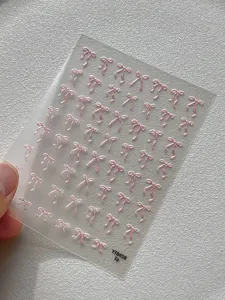 Primer plano de pegatinas de uñas con lazo rosa 3D, diseño holográfico brillante, hoja de uñas.