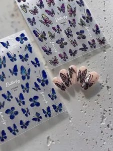 Detailed view of 3D iridescent butterfly nail stickers with adhesive and four-pointed star designs.