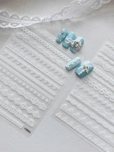 Detalle de pegatinas de uñas de encaje blanco con delicados patrones y lazos bonitos.
