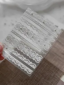 White lace pearl nail stickers detail view, embossed floral ribbon manicure decal design.