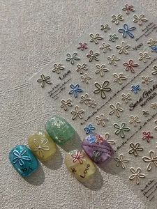 Detail view of 3D metallic floral nail art stickers sheet with colorful butterfly and flower designs.