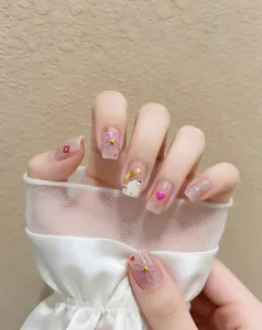 Detalle uñas postizas florales bonitas primavera verano, pegatinas de corazón y estrellas.
