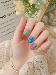 Close-up detail shot of colorful 3D floral nail art stickers with textured background design.