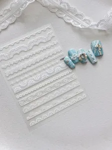 Hoja de pegatinas de unas de encaje en relieve 3D blanco con detalles de arte de unas de lazo azul.