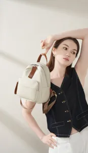 Close-up van een stijlvolle casual lederen rugzak in beige met bruine banden, detail.