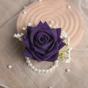 Détail de l'élégante fleur de poignet en rose artificielle violette pour mariages.