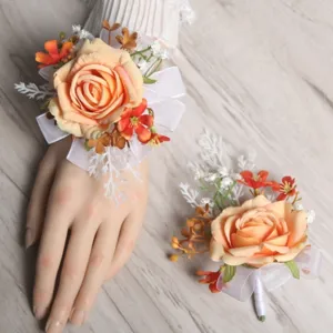 Detailed view of artificial peach rose wrist corsage and boutonniere set for wedding decoration.