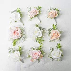 Set van trouw-boutonnieres in bosstijl, mooie kunstmatige rozen met groene bladeren.