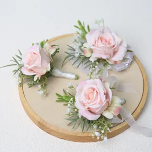 Roze kunstmatige roos huwelijk corsage en polsbloem set met groene bladeren voor bruiloft.