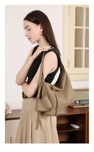 Vista dettagliata della borsa a spalla minimalista in vera pelle indossata dalla modella.