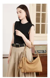 Elegante borsa a spalla in pelle beige indossata dalla modella, stile minimalista quotidiano.