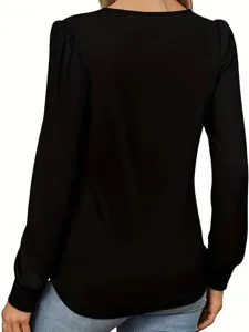 Detalle de blusa negra de manga larga, con elegante diseño plisado en los hombros para mujeres.